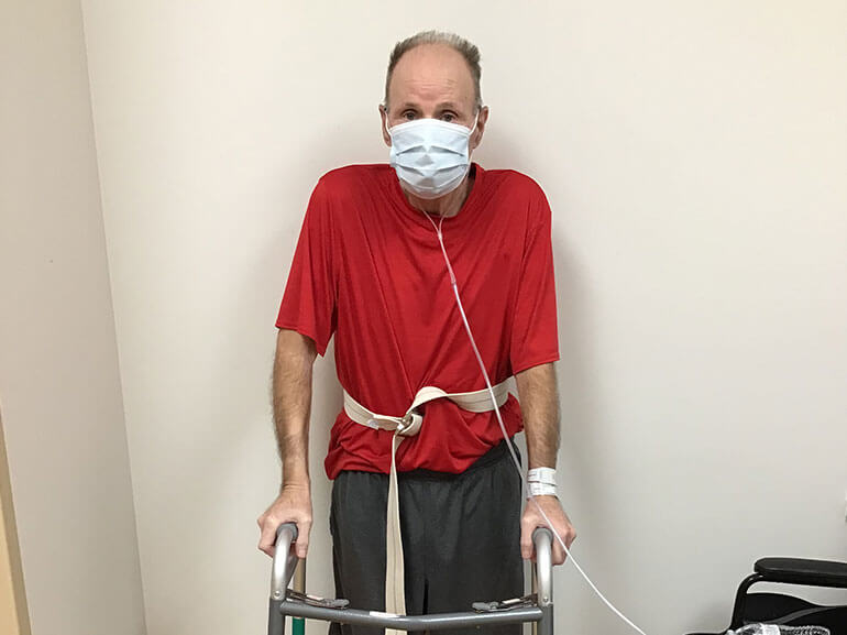 Michael using a walker to stand up. 