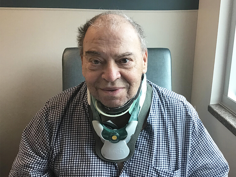James wearing a cervical neck brace and sitting in his hospital room.