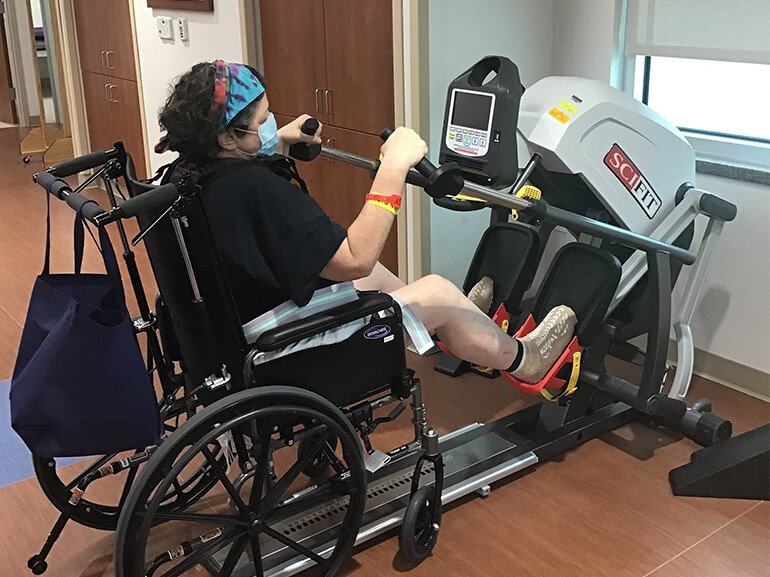 Karen using a total body exerciser in a therapy session.