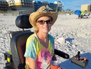 Miranda Gill smiles at the beach in her sand wheelchair.